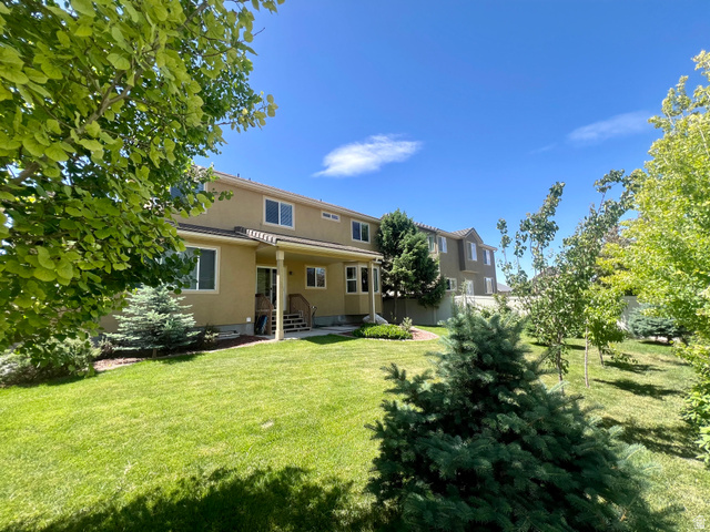 369 Culross Circle Tooele, UT 84074 - Photo 47 of 54 Expansive rear yard featuring a manicured lawn, established landscaping, and mature trees