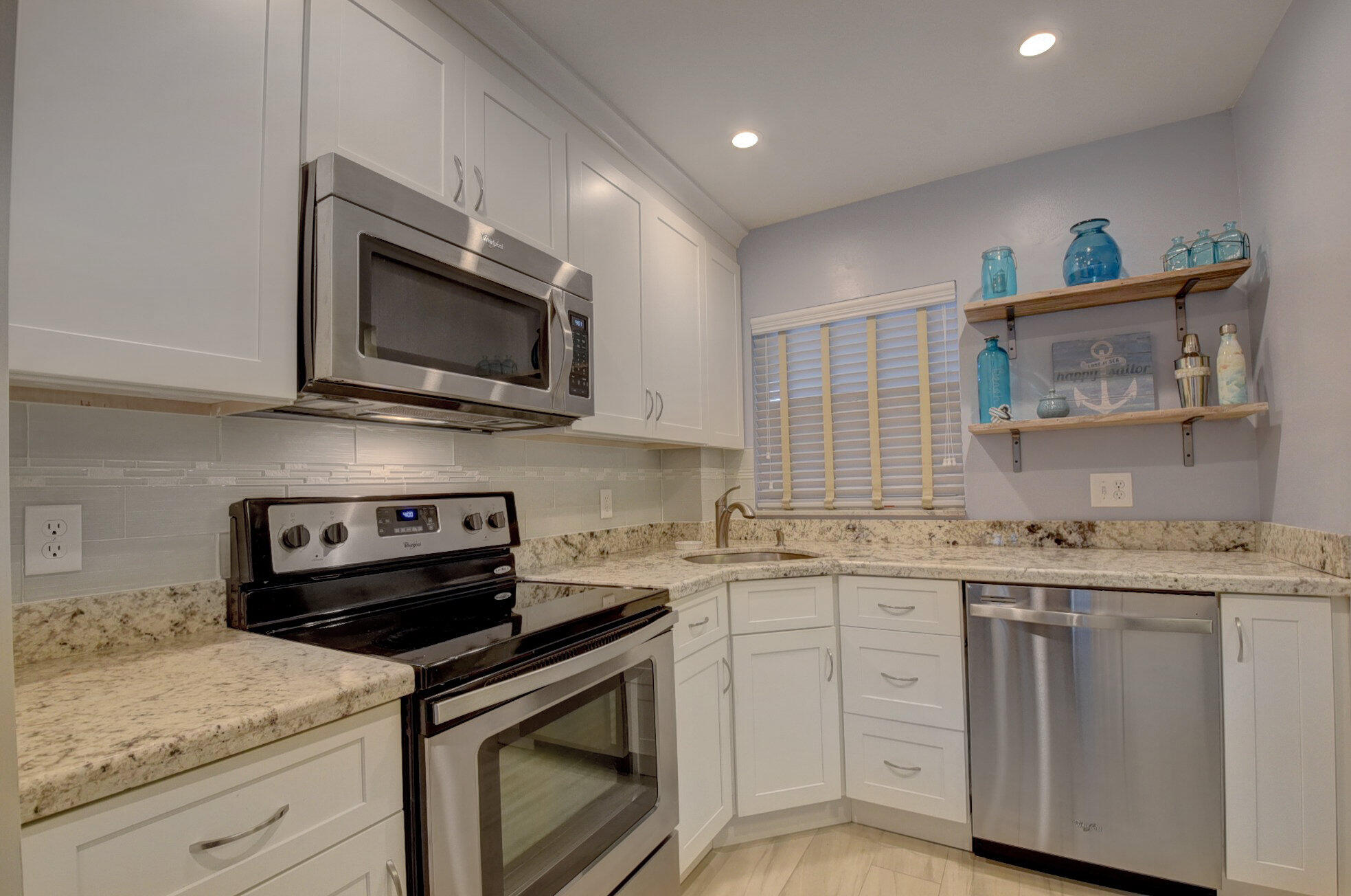 650 Snug Harbor Drive, Unit G307 Boynton Beach, FL 33435 - Photo 16 of 58 a kitchen with stainless steel appliances granite countertop a stove microwave and cabinets