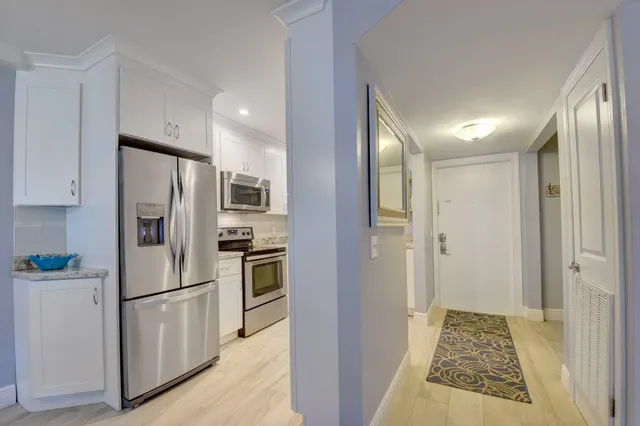 a kitchen with stainless steel appliances granite countertop a refrigerator and a stove