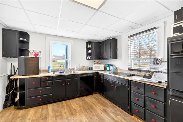 a kitchen with stainless steel appliances granite countertop a sink dishwasher a stove and a refrigerator with wooden floor