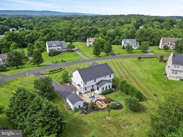 an aerial view of a residential houses with outdoor space and trees