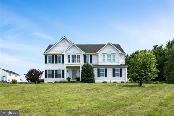 a front view of a house with a garden and yard