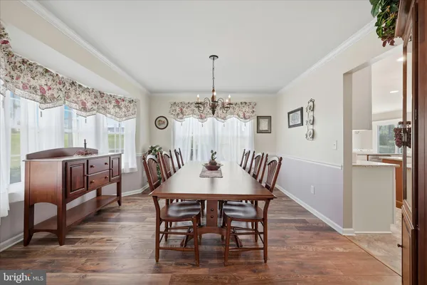 a kitchen with stainless steel appliances granite countertop a table chairs and a refrigerator