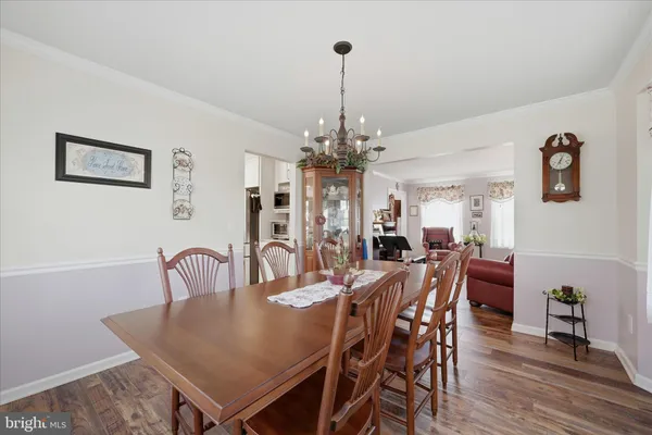 a close view of a dining table chairs and a chandelier