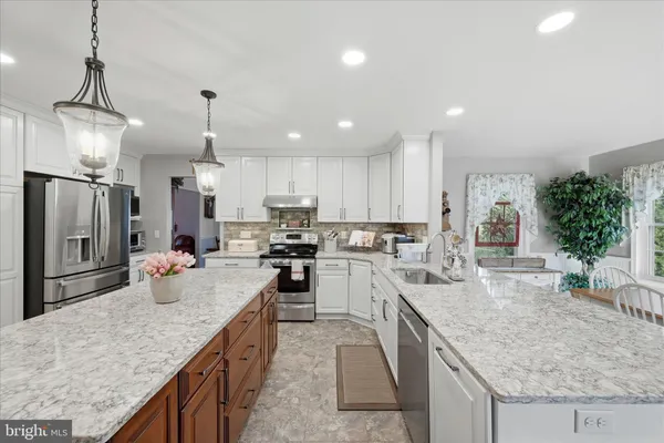a view of a dining room and livingroom with furniture wooden floor a chandelier