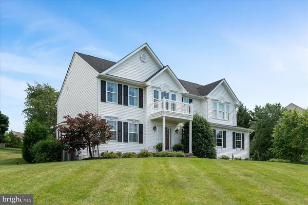 a front view of a house with a yard and trees