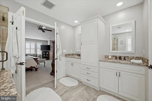 a bathroom with a toilet sink vanity and mirror