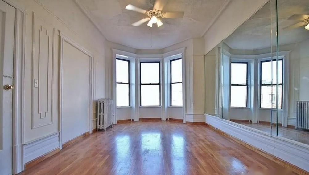 1595 Union Street Brooklyn, NY 11213 - Photo 21 of 21 an empty room with wooden floor and windows