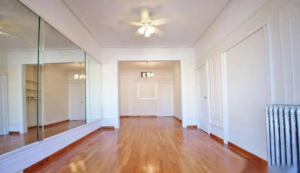 1595 Union Street Brooklyn, NY 11213 - Photo 4 of 21 a view of a room with wooden floor and a ceiling fan