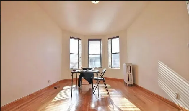 a view of a room with wooden floor and a window