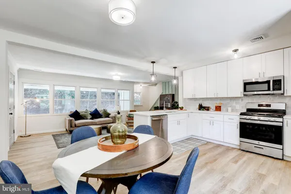 a open dining room with kitchen island furniture a large window and kitchen view
