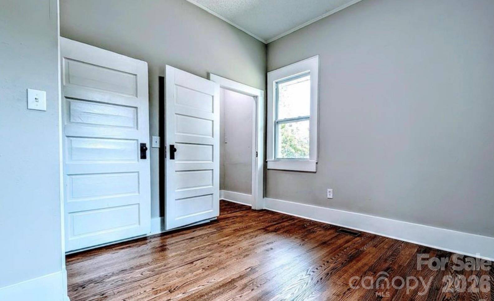 113 Brawley Street Chester, SC 29706 - Photo 3 of 12 a view of an empty room with a window and wooden floor