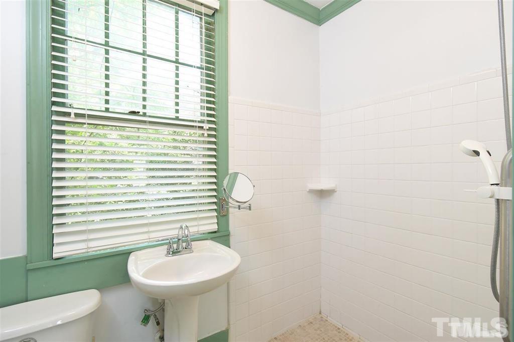 225 Hillcrest Road Raleigh, NC 27605 - Photo 7 of 18 a bathroom with a toilet a sink and a mirror