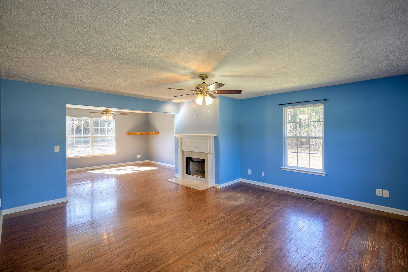 7042 Murfreesboro Road Lebanon, TN 37090 - Photo 9 of 43 a view of an empty room with wooden floor fireplace and a window