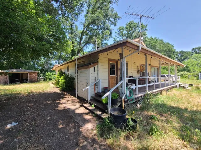 a view of a wooden house with a yard