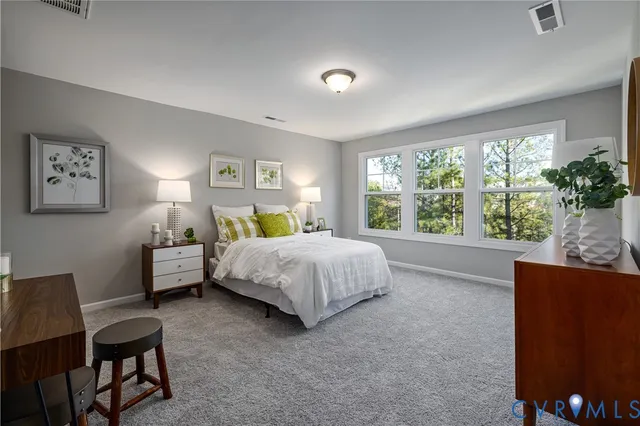 a spacious bedroom with a bed and a dresser next to a window