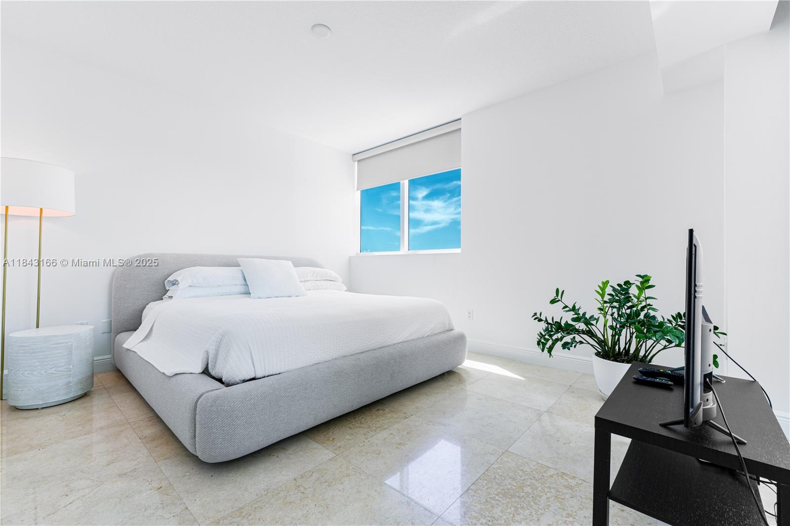 3801 Collins Avenue, Unit 1105 Miami Beach, FL 33140 - Photo 16 of 45 a spacious bedroom with a bed and a potted plant