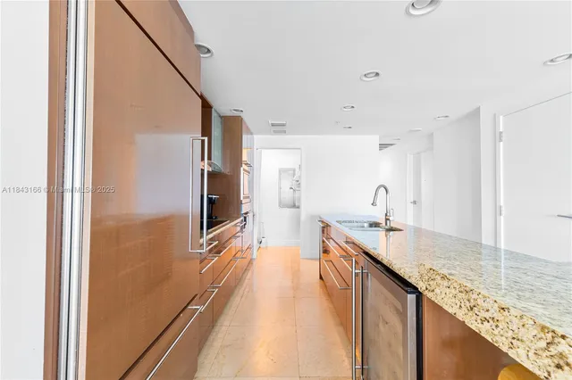 a kitchen with stainless steel appliances granite countertop a stove top oven a sink and dishwasher