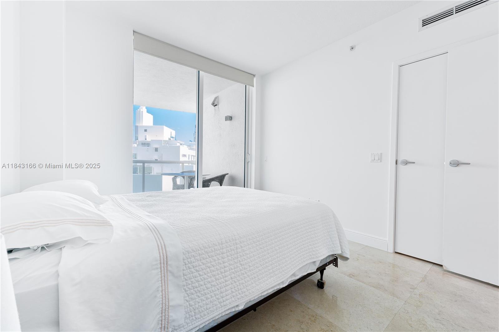 3801 Collins Avenue, Unit 1105 Miami Beach, FL 33140 - Photo 28 of 45 a bedroom with a bed and a mirror