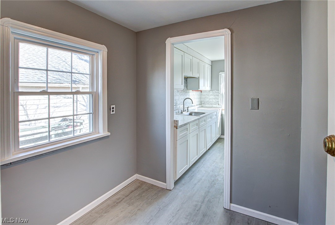 3423 Westbury Road Cleveland, OH 44120 - Photo 29 of 38 Hallway with a wealth of natural light, sink, and light hardwood / wood-style floors