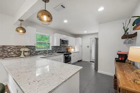 a kitchen with stainless steel appliances granite countertop a sink stove and refrigerator