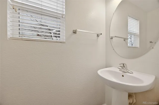 a bathroom with a sink a mirror and a window