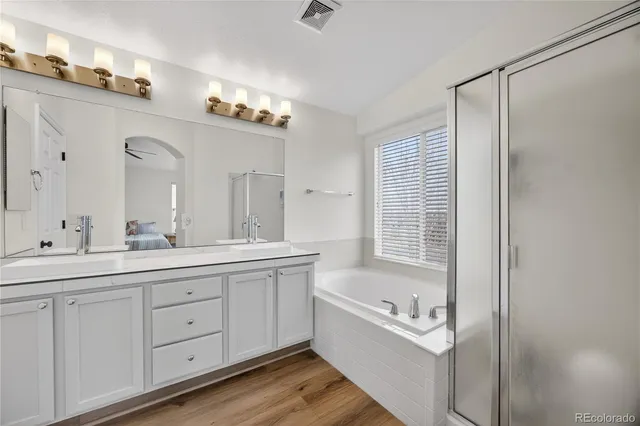 a bathroom with a bathtub sink double vanity and mirror