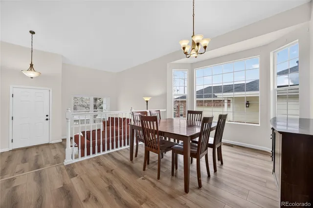 a dining room with furniture a chandelier and wooden floor