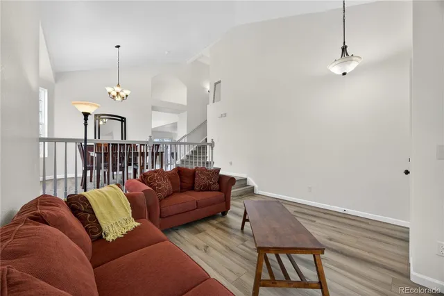 a living room with furniture a dining table and a chandelier