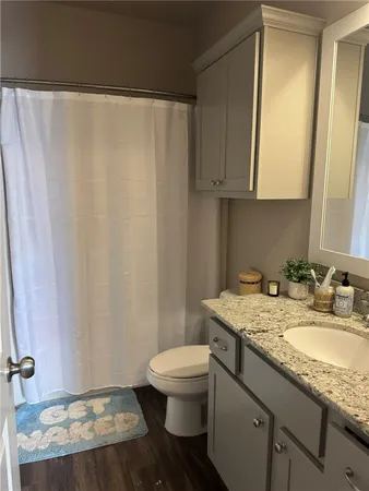 a bathroom with a granite countertop sink toilet and mirror