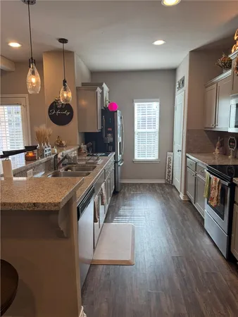 a kitchen with stainless steel appliances granite countertop a stove and a wooden floors