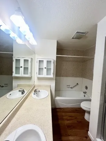 a bathroom with a granite countertop sink toilet and shower