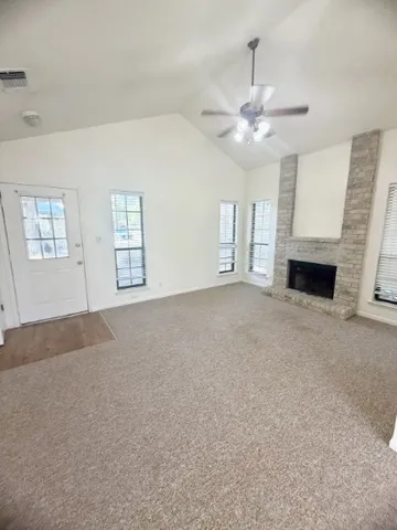 a view of livingroom with window fireplace and ceiling fan