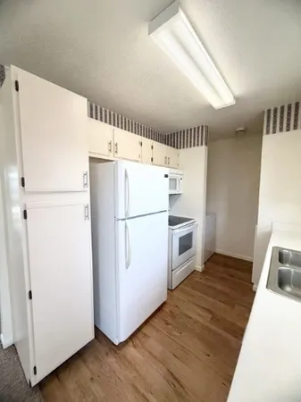 a white refrigerator freezer and a stove sitting inside of a kitchen
