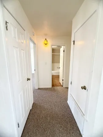a view of a livingroom with wooden floor and a bathroom