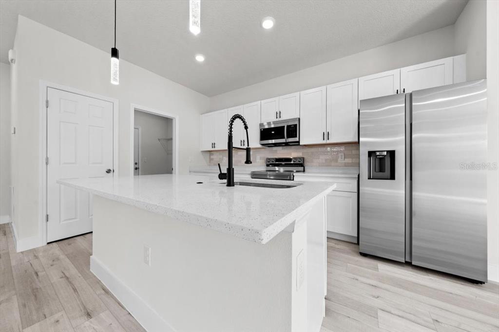 15495 Southwest 49th Avenue Road Ocala, FL 34473 - Photo 19 of 65 a kitchen with kitchen island white cabinets and stainless steel appliances