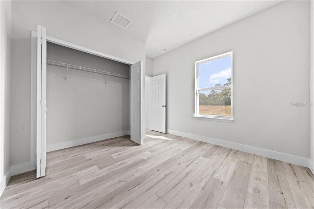 15495 Southwest 49th Avenue Road Ocala, FL 34473 - Photo 22 of 65 an empty room with wooden floor and windows