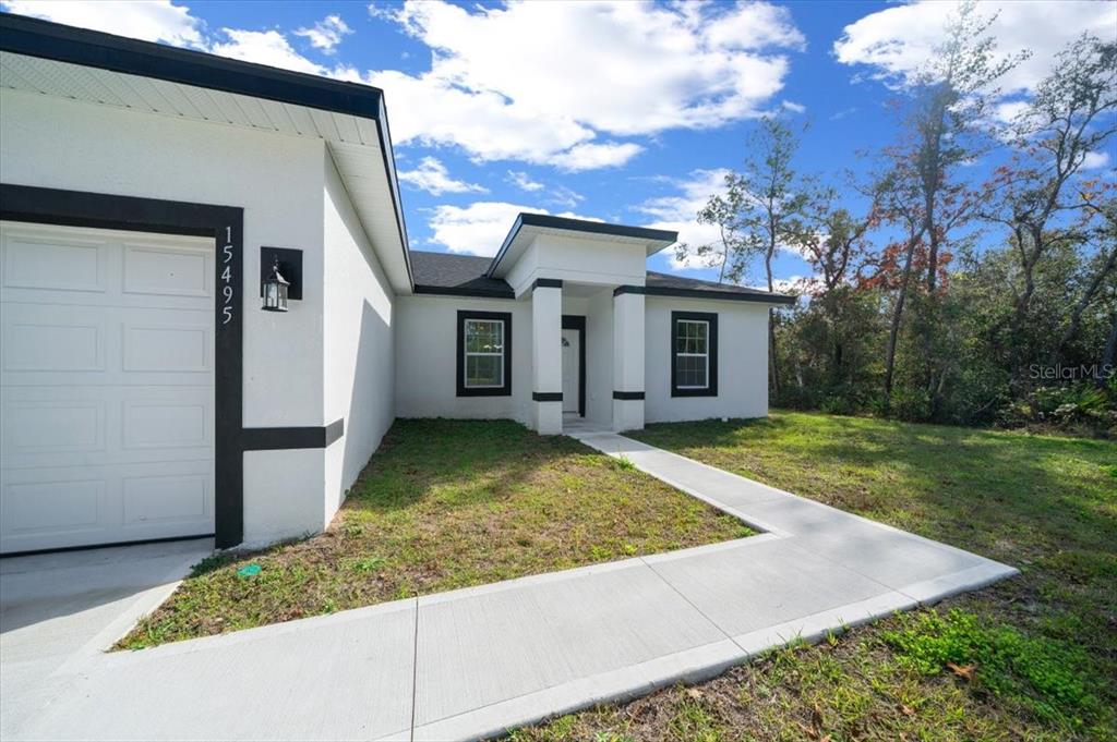 15495 Southwest 49th Avenue Road Ocala, FL 34473 - Photo 3 of 65 a view of a white house with a yard