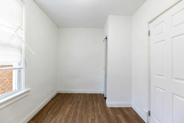 a view of a small space with wooden floor and a window