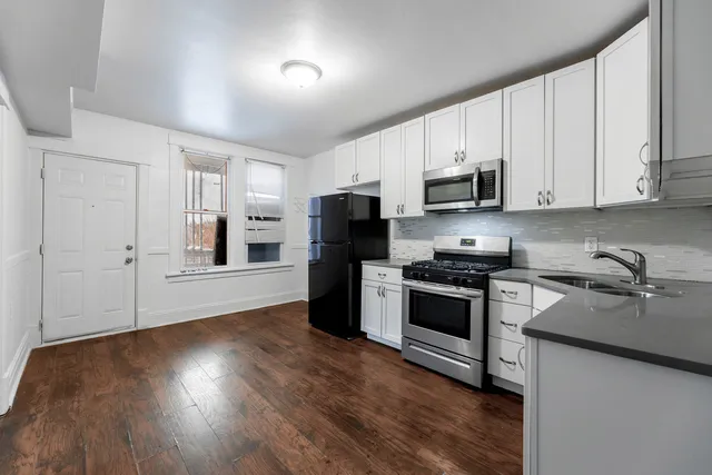 a kitchen with stainless steel appliances granite countertop a stove a sink and a refrigerator