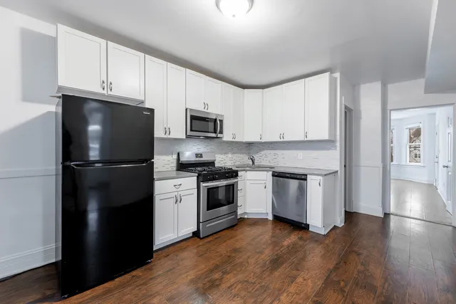 a kitchen with a refrigerator stove and wooden cabinets