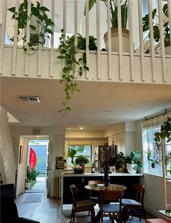 a room with lots of white furniture and potted plant
