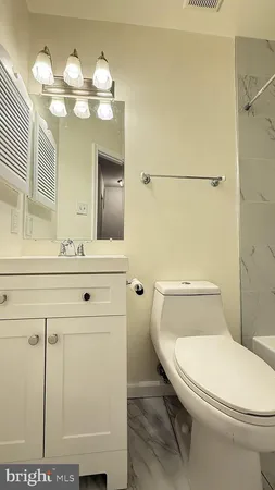 a bathroom with a toilet a sink and mirror