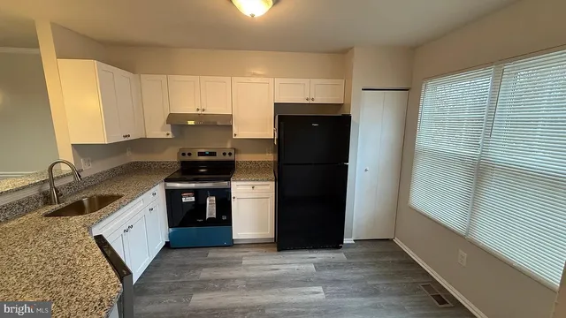 a kitchen with a refrigerator stove and cabinets