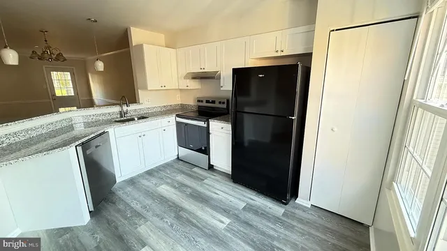a kitchen with granite countertop a refrigerator and a sink