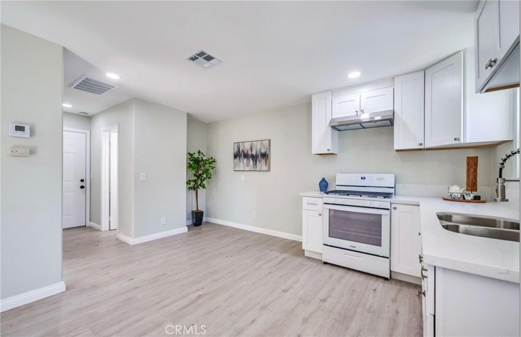 5510 Bushnell Avenue Riverside, CA 92505 - Photo 1 of 8 a kitchen with stainless steel appliances white cabinets and wooden floor