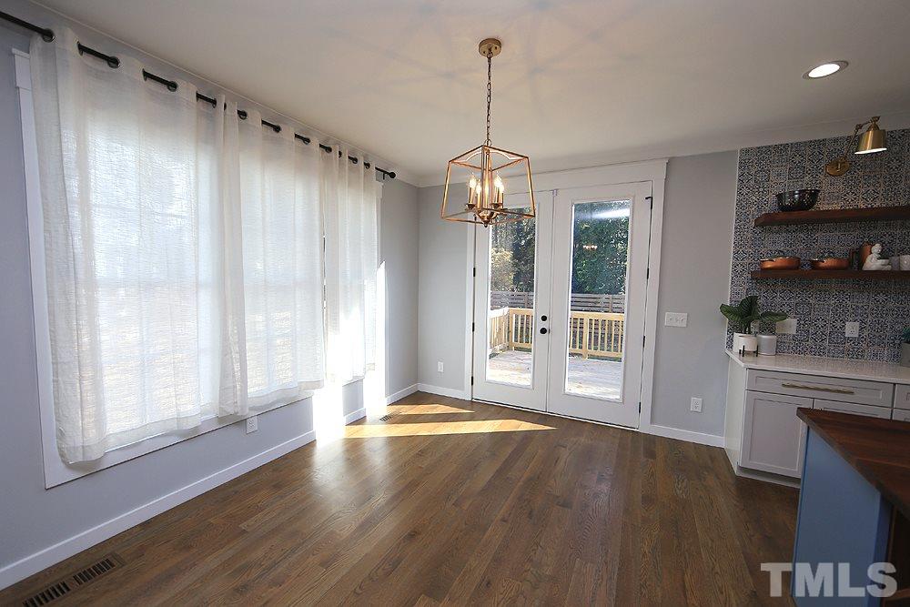 521 Bart Street Raleigh, NC 27610 - Photo 9 of 29 a view of a livingroom with a chandelier wooden floor and a kitchen