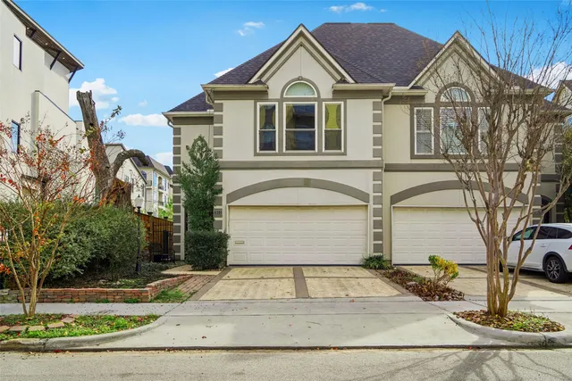 a view of a white house with large windows and palm tree