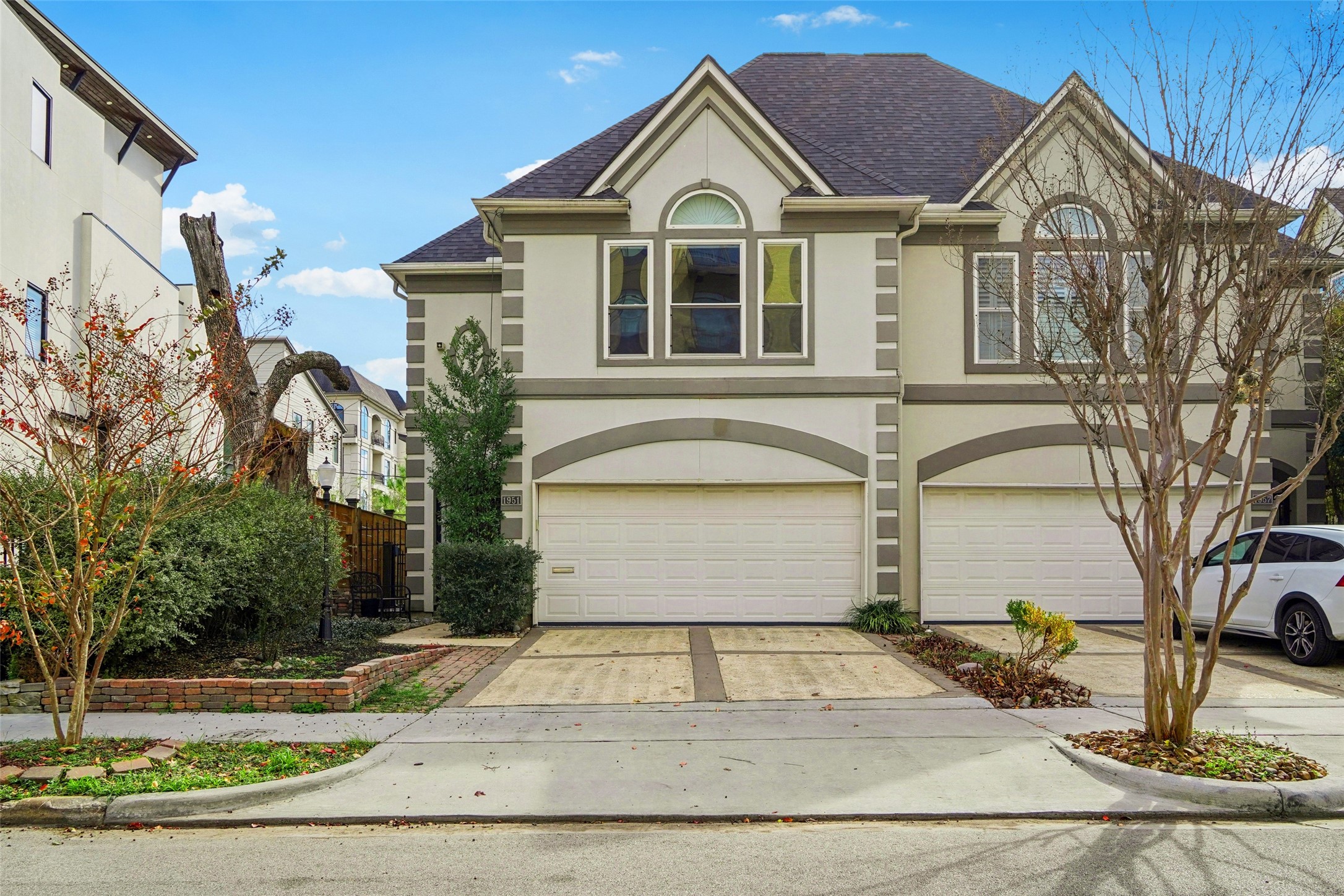 a view of a white house with large windows and palm tree