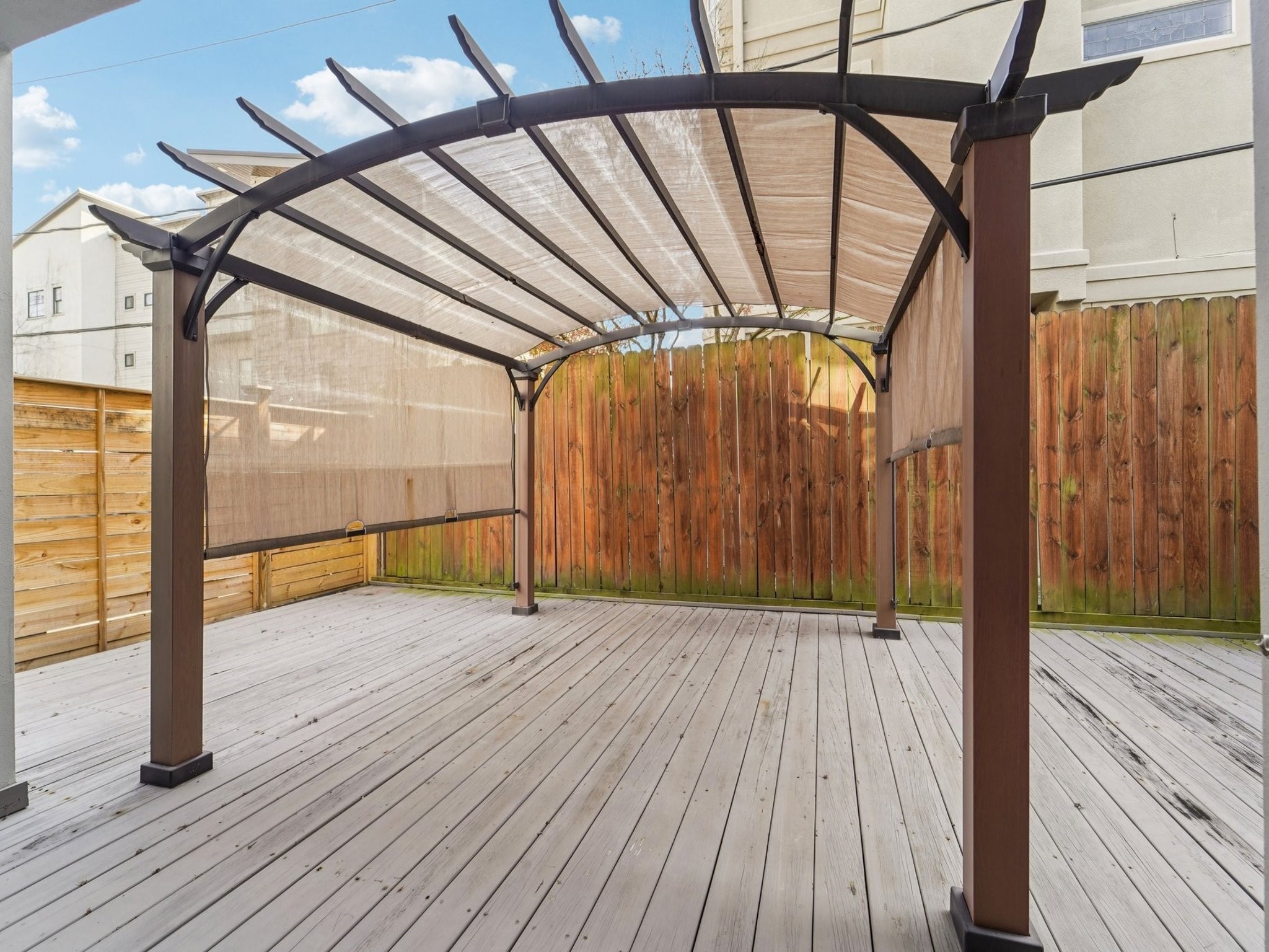 1951 West Clay Street Houston, TX 77019 - Photo 45 of 49 The backyard is decked and has a pergola to provide relief from the sun.